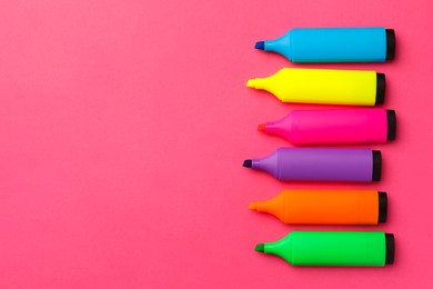 Photo of Bright color markers on pink background, flat lay. Space for text