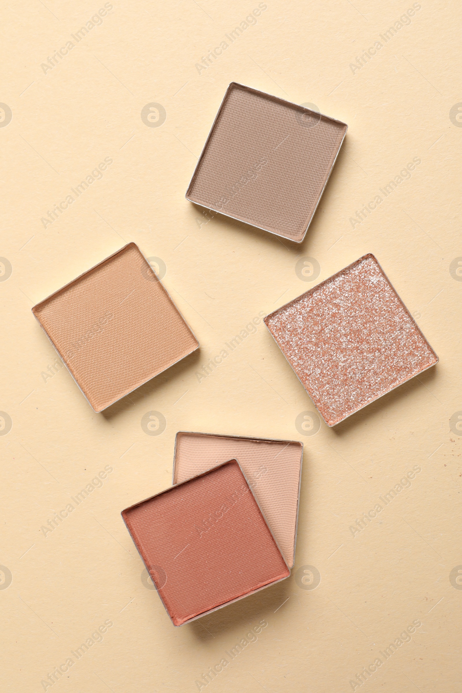 Photo of Different beautiful eye shadows on beige background, flat lay