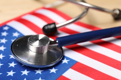 Photo of Stethoscope and USA flag on table, closeup. Health care concept