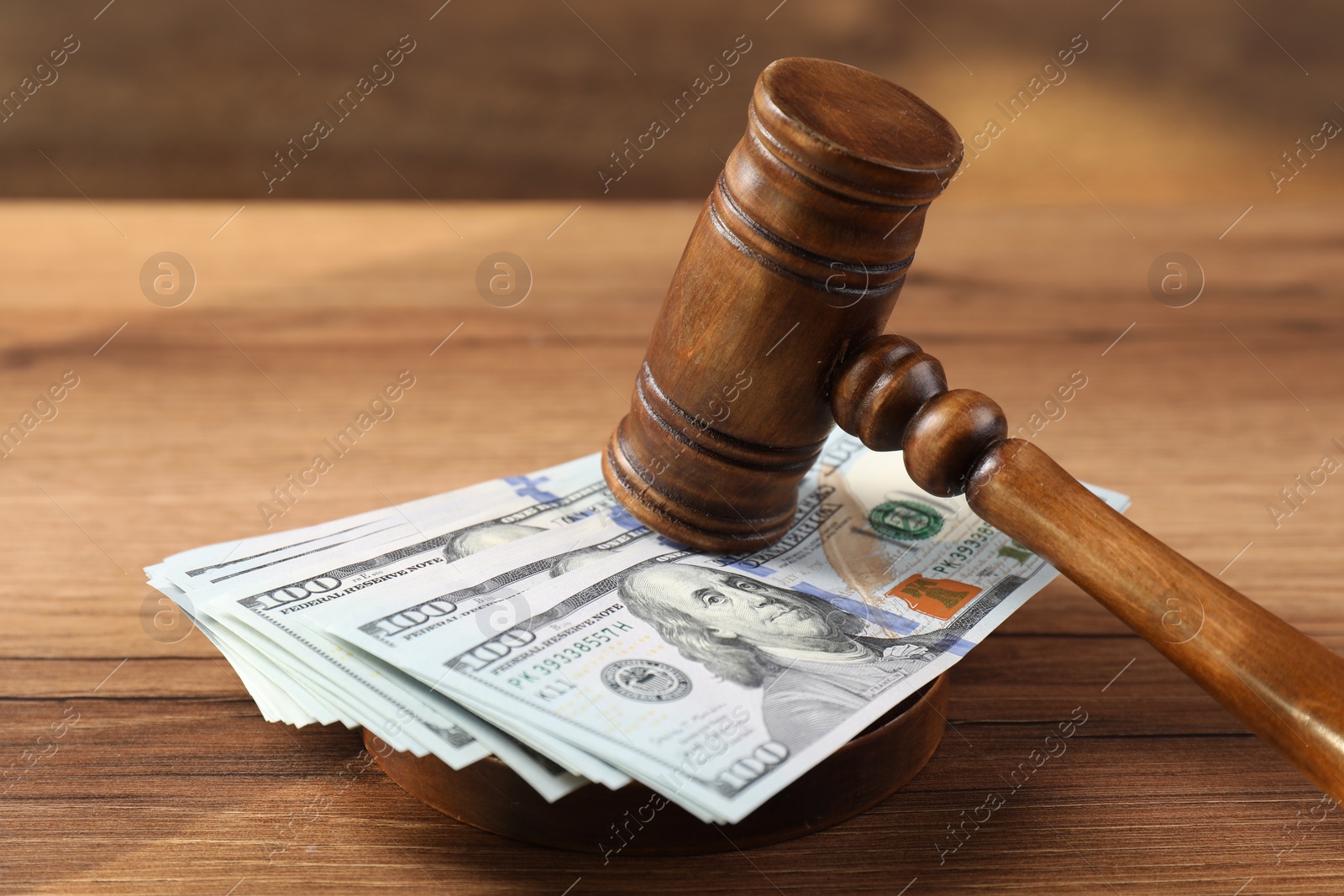 Photo of Judge's gavel and money on wooden table, closeup