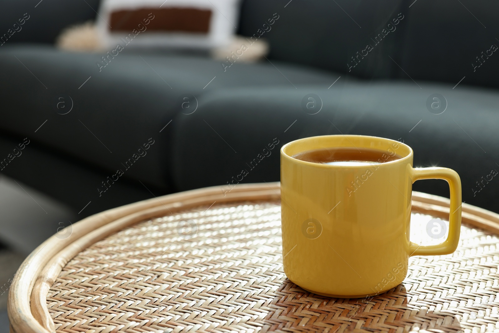 Photo of Ceramic mug of tea on wicker table indoors. Mockup for design