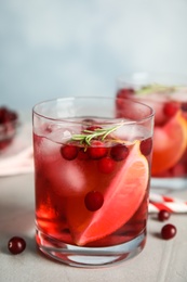 Photo of Tasty refreshing cranberry cocktail on light grey table