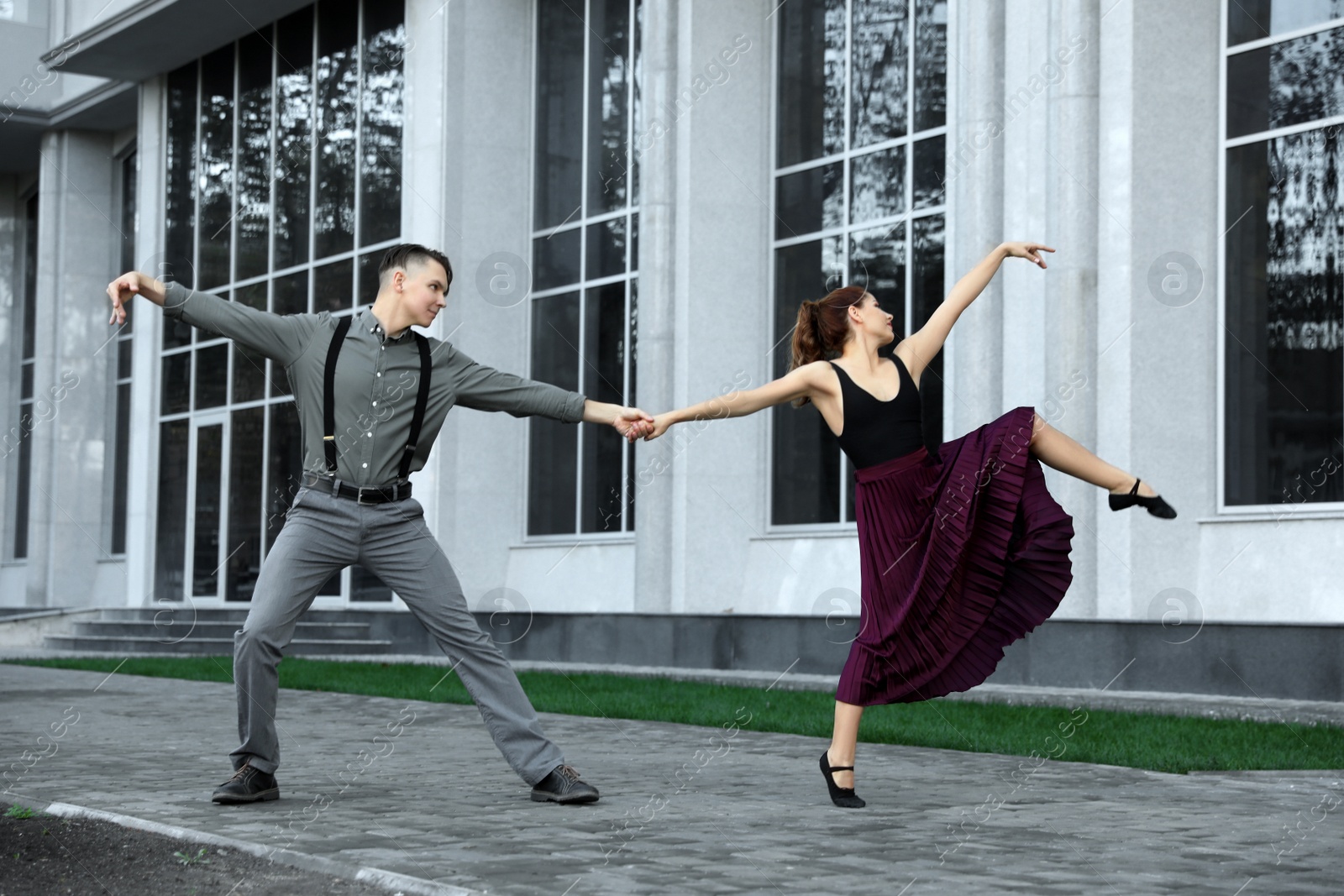 Photo of Beautiful young couple practicing dance moves on city street