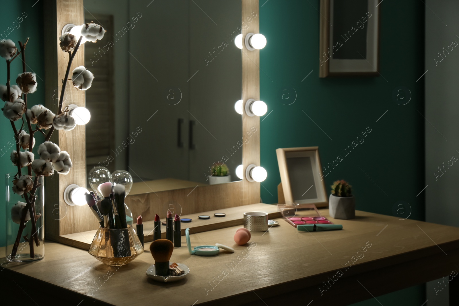 Photo of Decorative cosmetics and tools on dressing table near mirror in makeup room