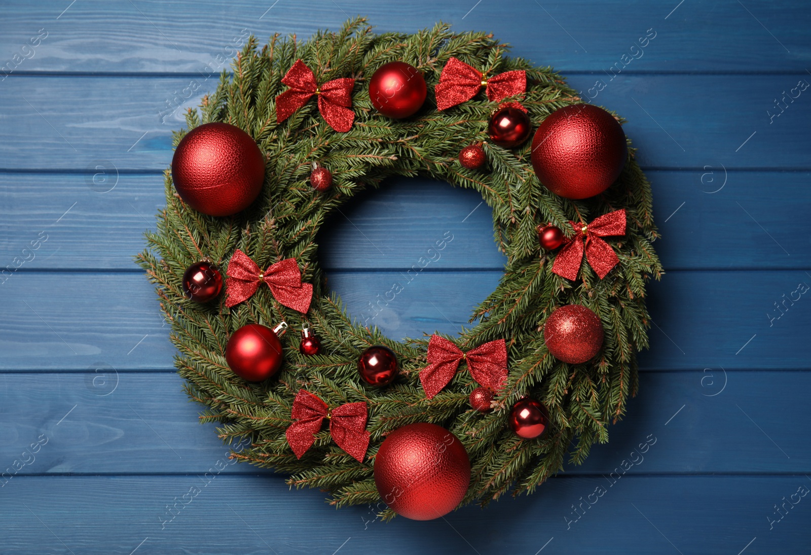 Photo of Beautiful Christmas wreath on blue wooden background, top view