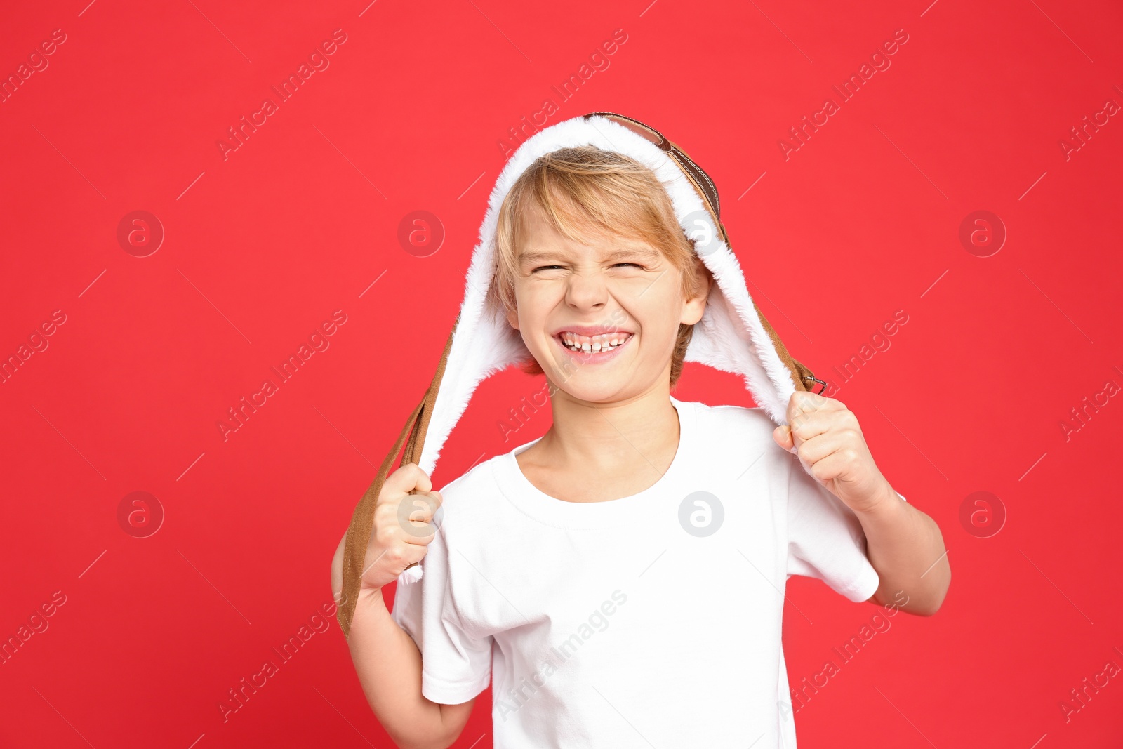 Photo of Happy little boy wearing hat on red background