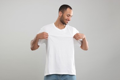 Man wearing white t-shirt on gray background