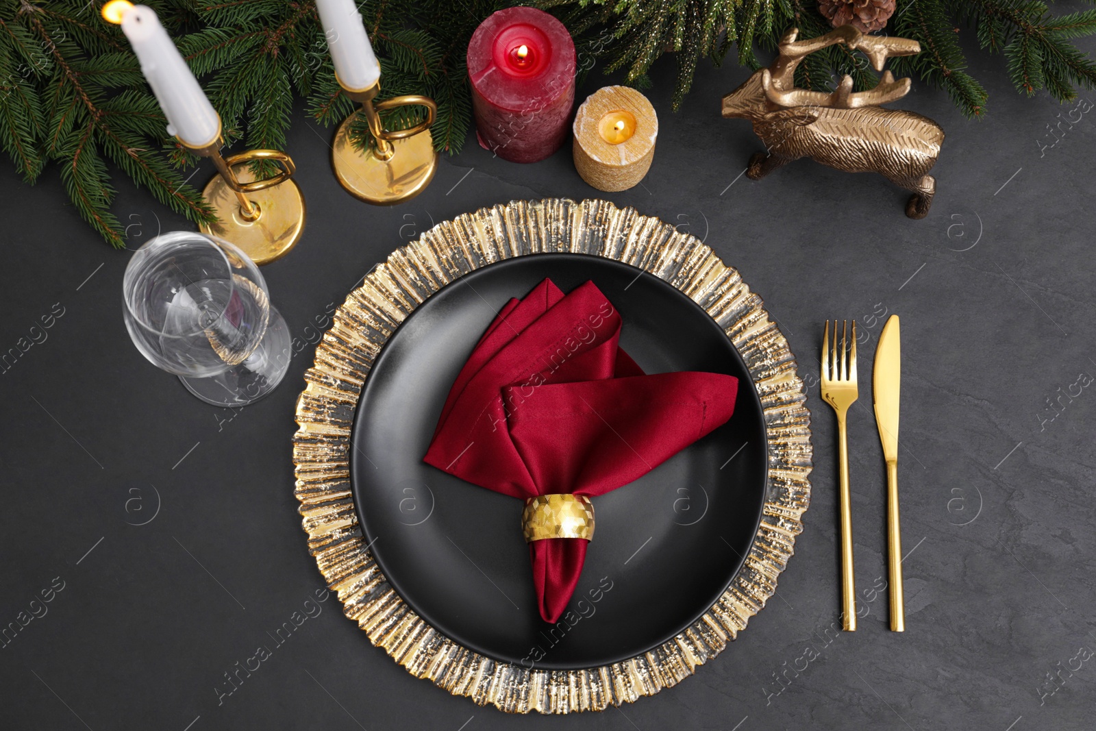 Photo of Festive place setting with beautiful dishware, cutlery and fabric napkin for Christmas dinner on grey table, flat lay