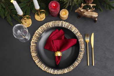 Photo of Festive place setting with beautiful dishware, cutlery and fabric napkin for Christmas dinner on grey table, flat lay