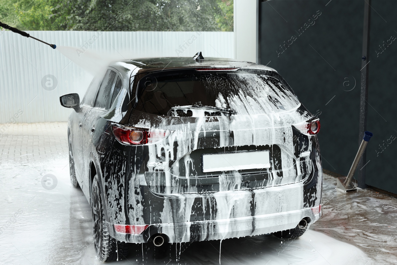Photo of Washing auto with high pressure water jet at outdoor car wash