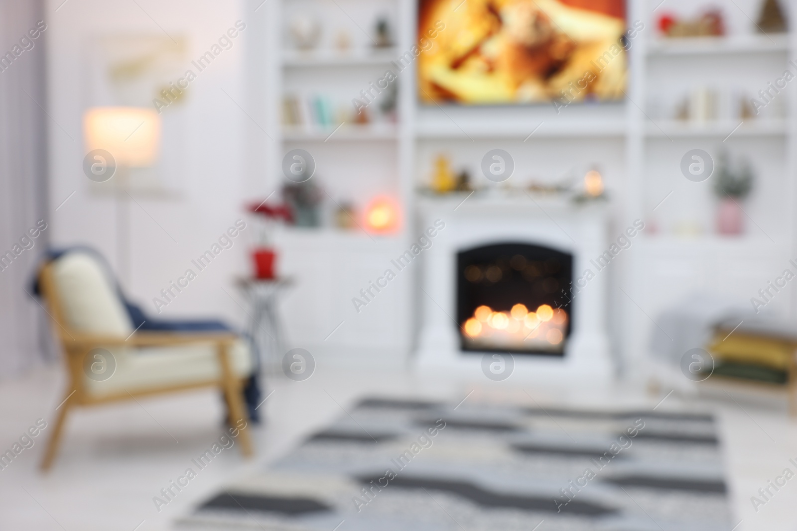 Photo of Blurred view of beautiful living room with Christmas decor, fireplace and armchair. Interior design