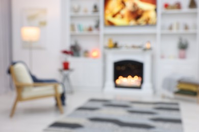 Blurred view of beautiful living room with Christmas decor, fireplace and armchair. Interior design