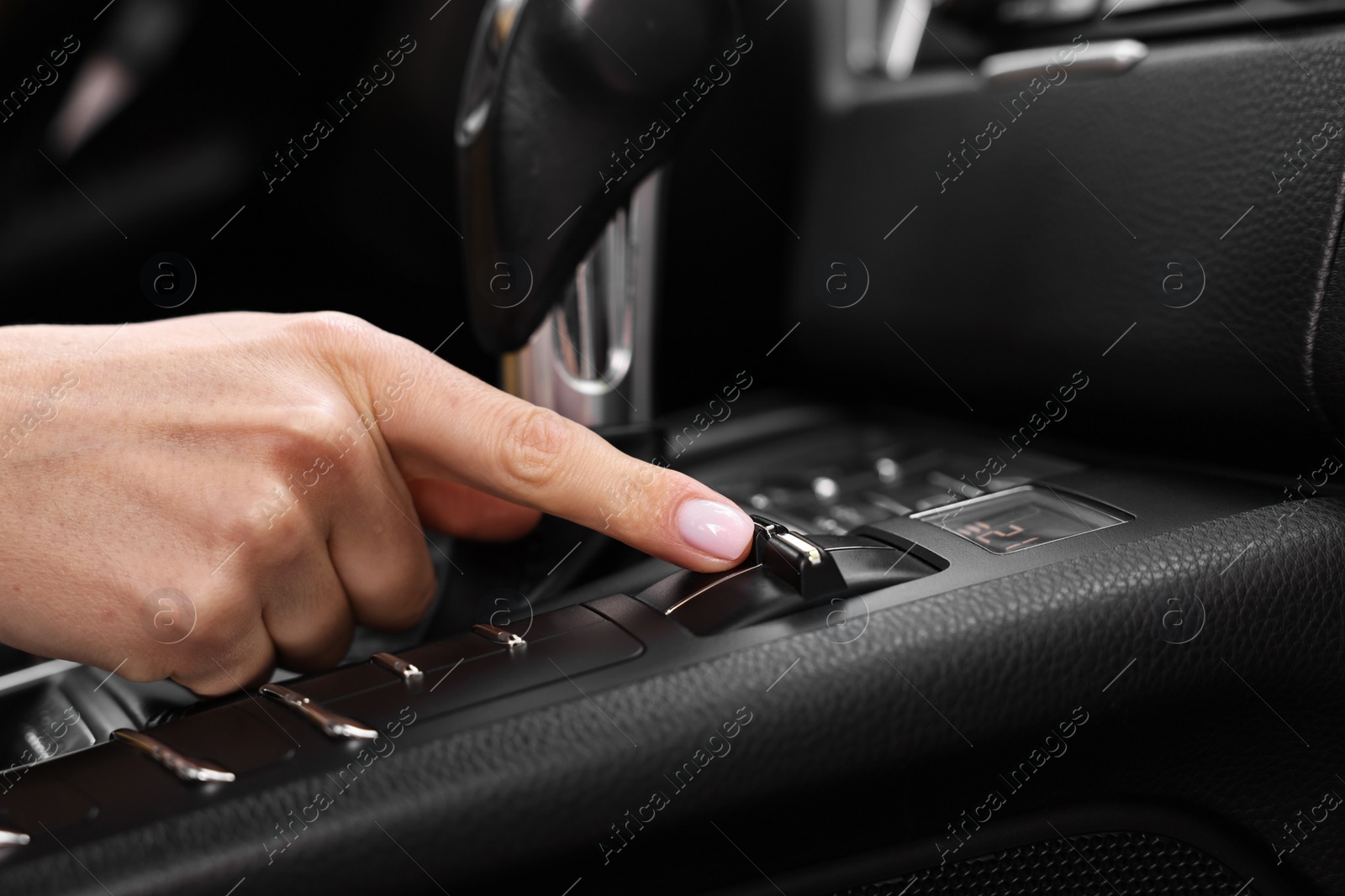 Photo of Woman using gear stick while driving her car, closeup