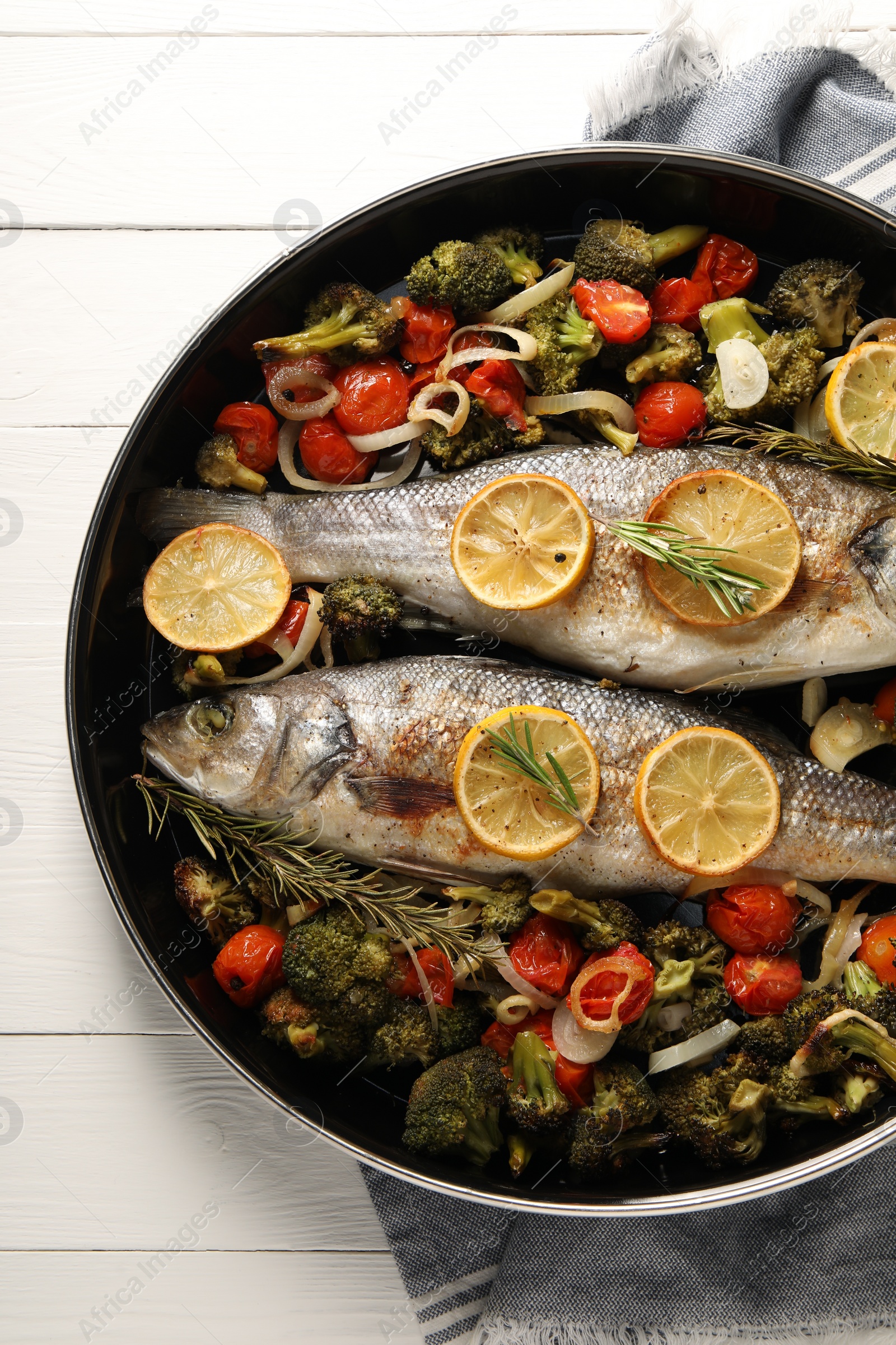 Photo of Baked fish with vegetables, rosemary and lemon on white wooden table, top view