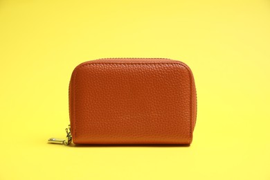 Photo of Stylish brown leather purse on yellow background