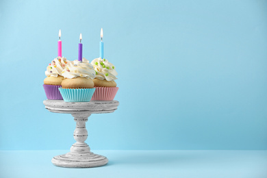 Birthday cupcakes with candles on light blue background, Space for text