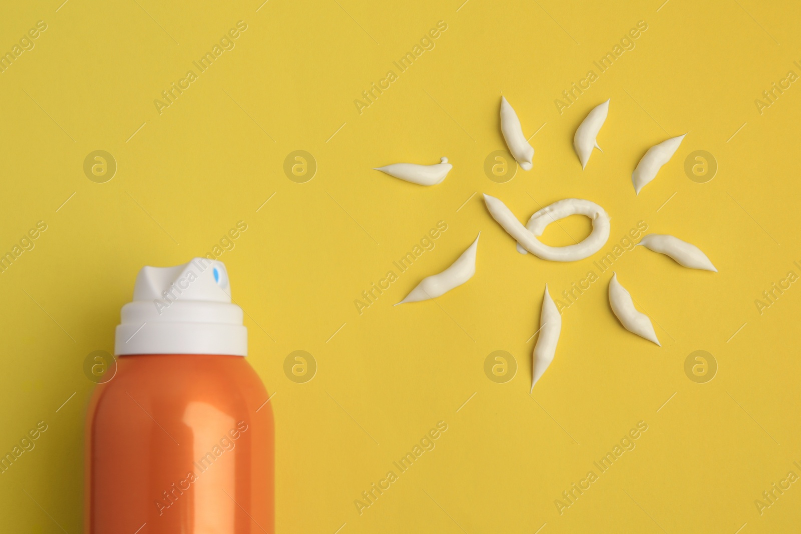 Photo of Drawing of sun and bottle with sunscreen on yellow background, top view. Skin protection