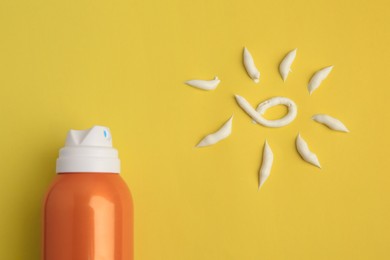 Photo of Drawing of sun and bottle with sunscreen on yellow background, top view. Skin protection