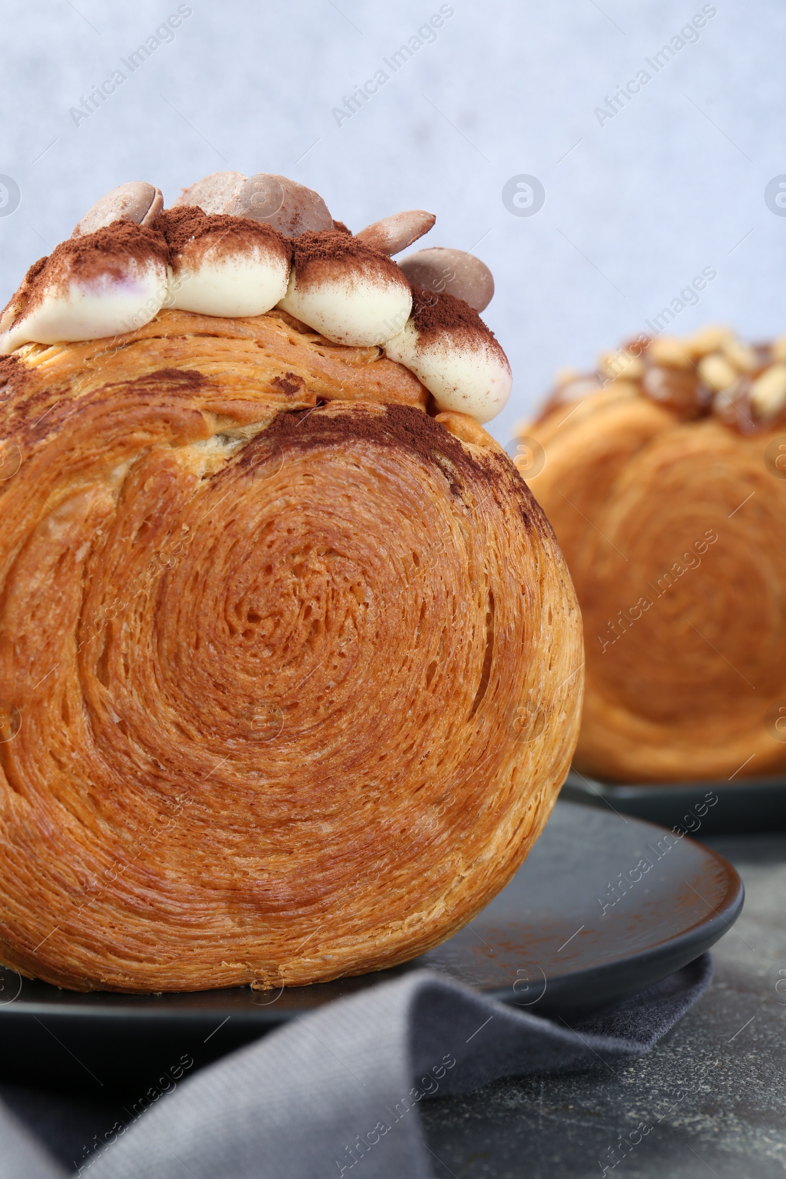 Photo of Crunchy round croissants on grey table, closeup. Tasty puff pastry