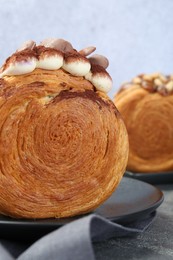 Crunchy round croissants on grey table, closeup. Tasty puff pastry