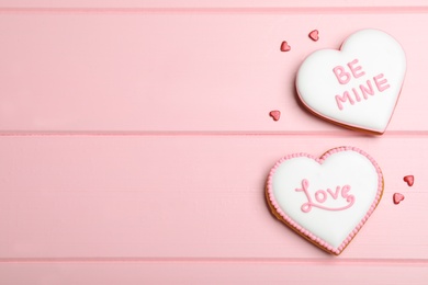 Photo of Valentine's day cookies with words Be Mine and Love on pink table, flat lay. Space for text