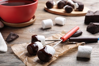 Photo of Delicious marshmallows covered with chocolate on wooden table