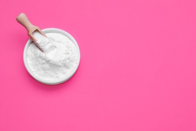 Photo of Bowl of sweet powdered fructose on pink background, top view. Space for text