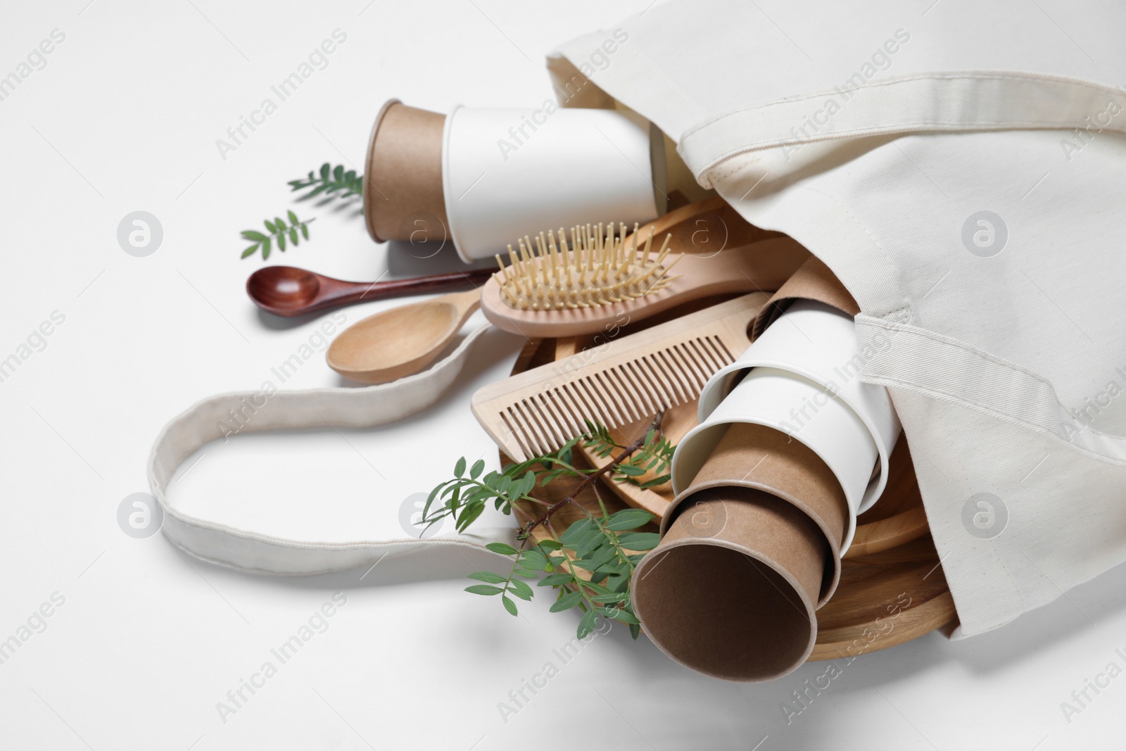Photo of Eco bag with different disposable items on white background, closeup. Recycling concept