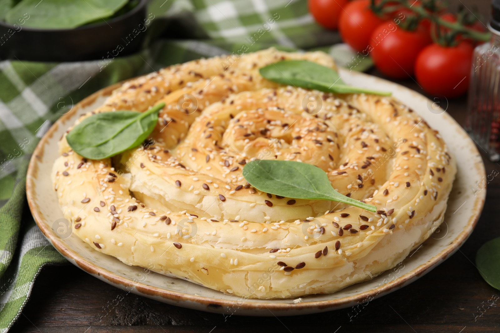 Photo of Delicious puff pastry with spinach on wooden table, closeup