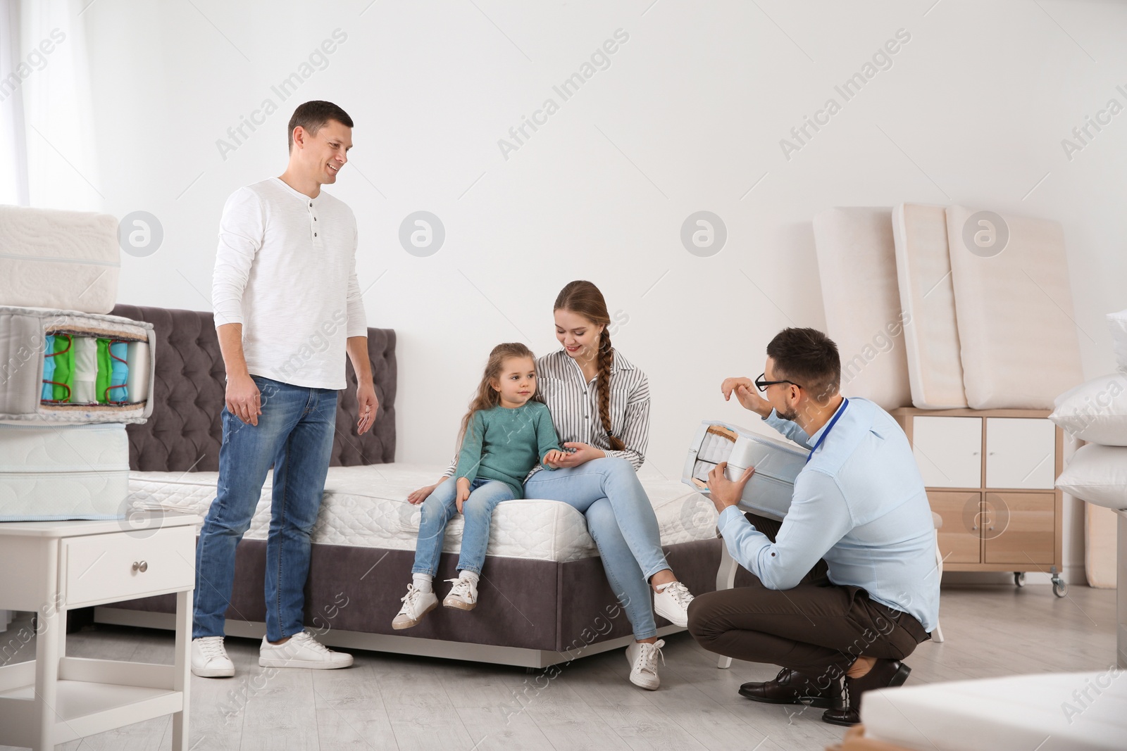 Photo of Salesman showing family section of mattress at store