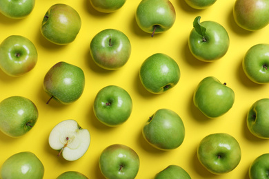 Photo of Tasty green apples on yellow background, flat lay