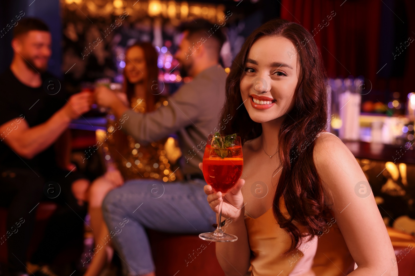 Photo of Friends spending time together in bar. Beautiful woman with fresh alcoholic cocktail, space for text