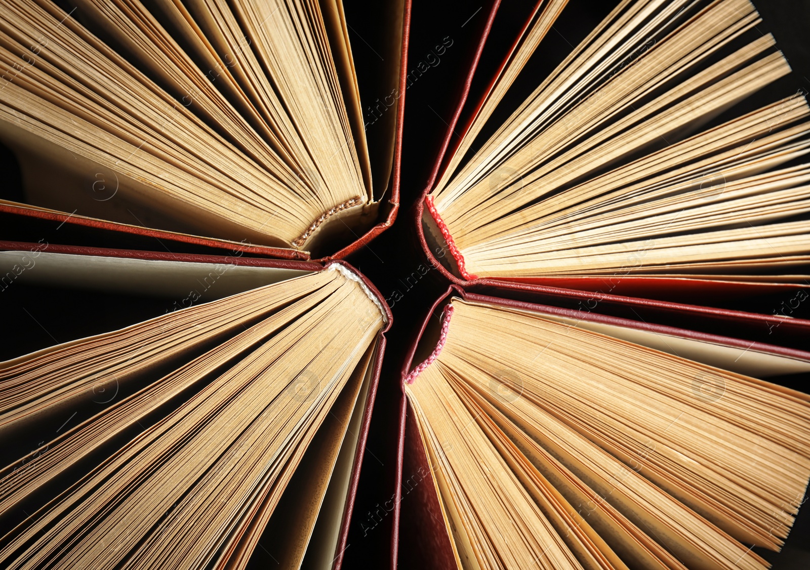 Photo of Many different hardcover books on dark background, top view