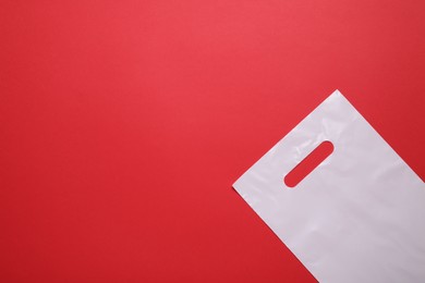 White plastic bag on red background, top view. Space for text