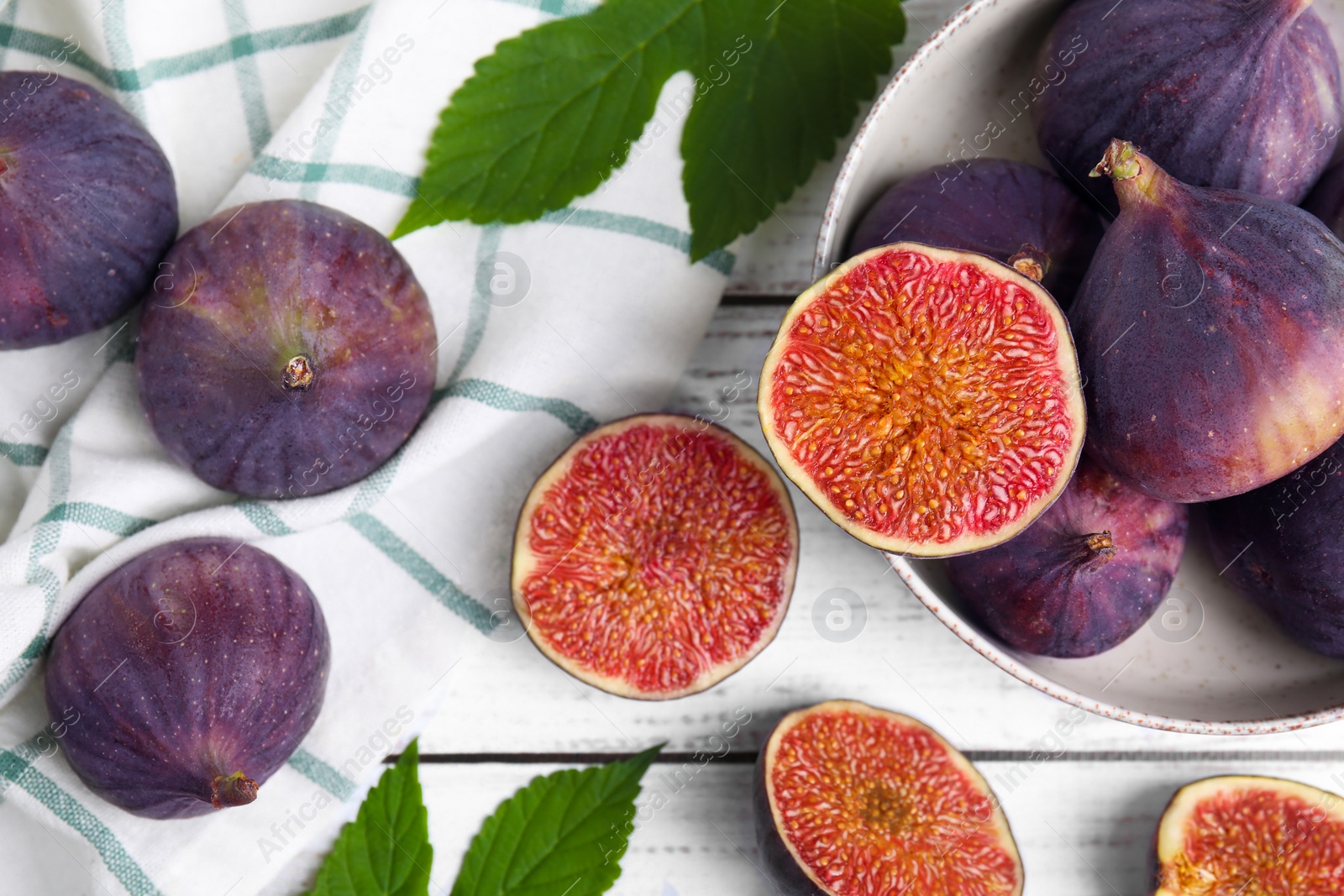 Photo of Fresh ripe figs on white wooden table, flat lay