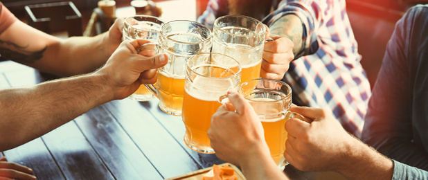 Image of Group of friends toasting with beer in pub, closeup. Banner design