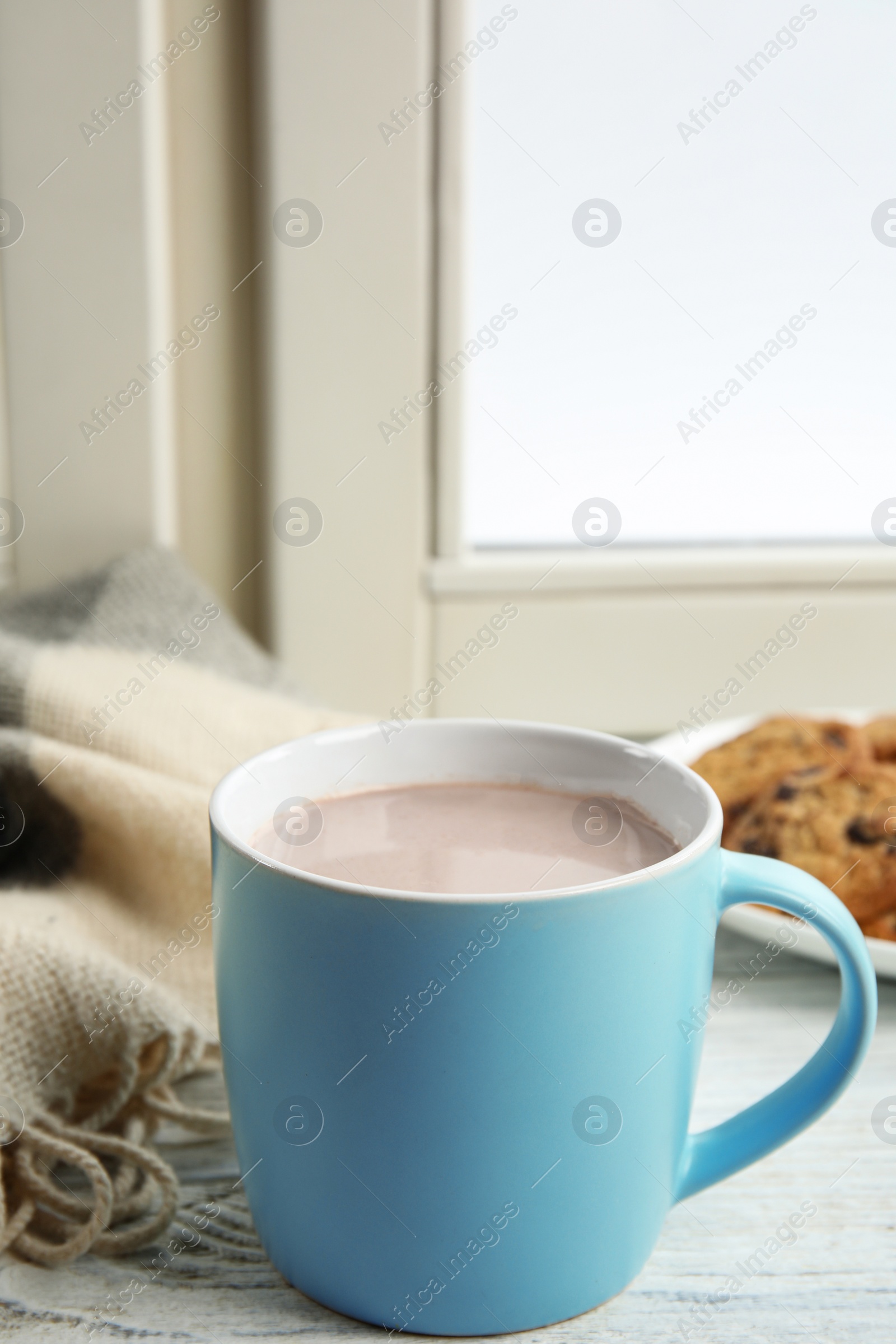 Photo of Cup of hot cocoa on window sill. Winter drink