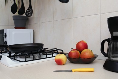 Photo of Fresh apples and coffeemaker near gas cooktop in kitchen