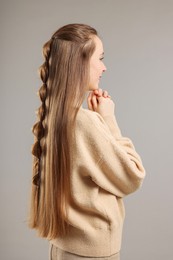 Woman with braided hair on grey background