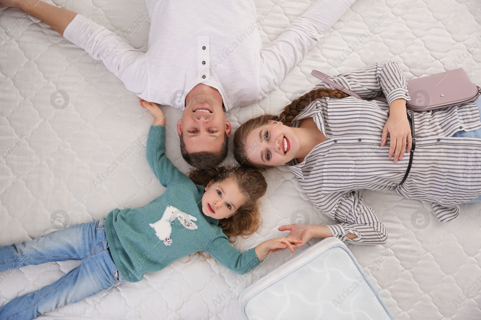 Photo of Happy family testing mattress in store, top view