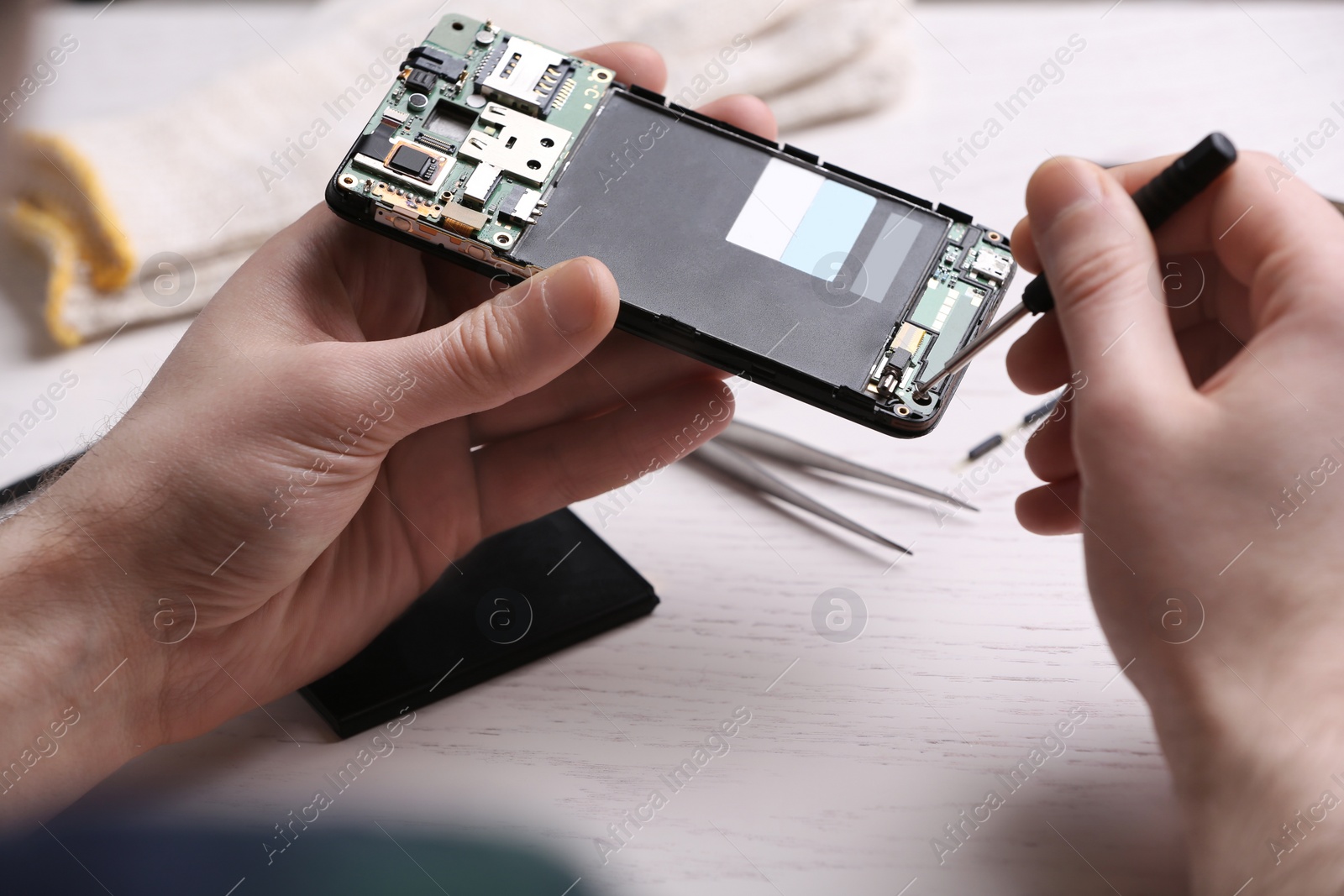 Photo of Technician fixing mobile phone at table, closeup. Device repair service