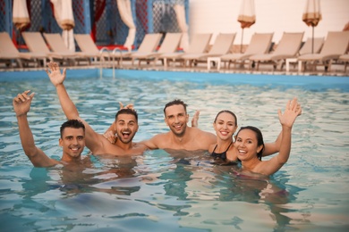 Photo of Happy young friends spending time in swimming pool