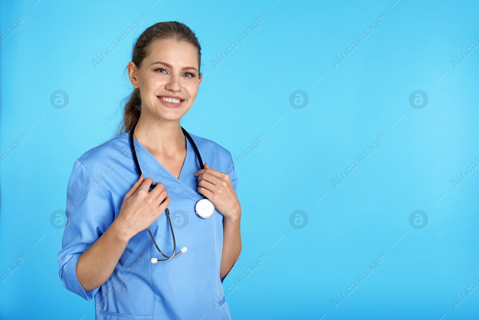 Photo of Portrait of young medical assistant with stethoscope on color background. Space for text