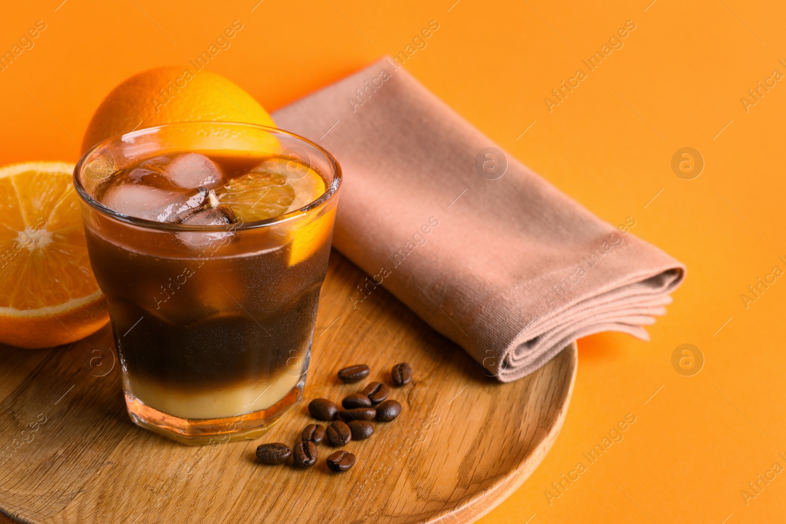 Photo of Tasty refreshing drink with coffee and orange juice on bright color background