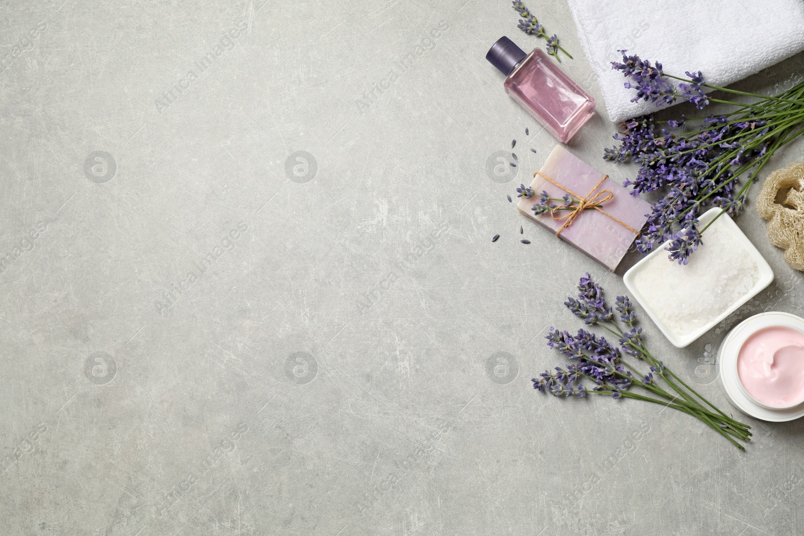 Photo of Cosmetic products and lavender flowers on light table, flat lay. Space for text