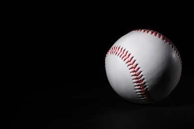 Photo of One baseball ball on black background. Space for text