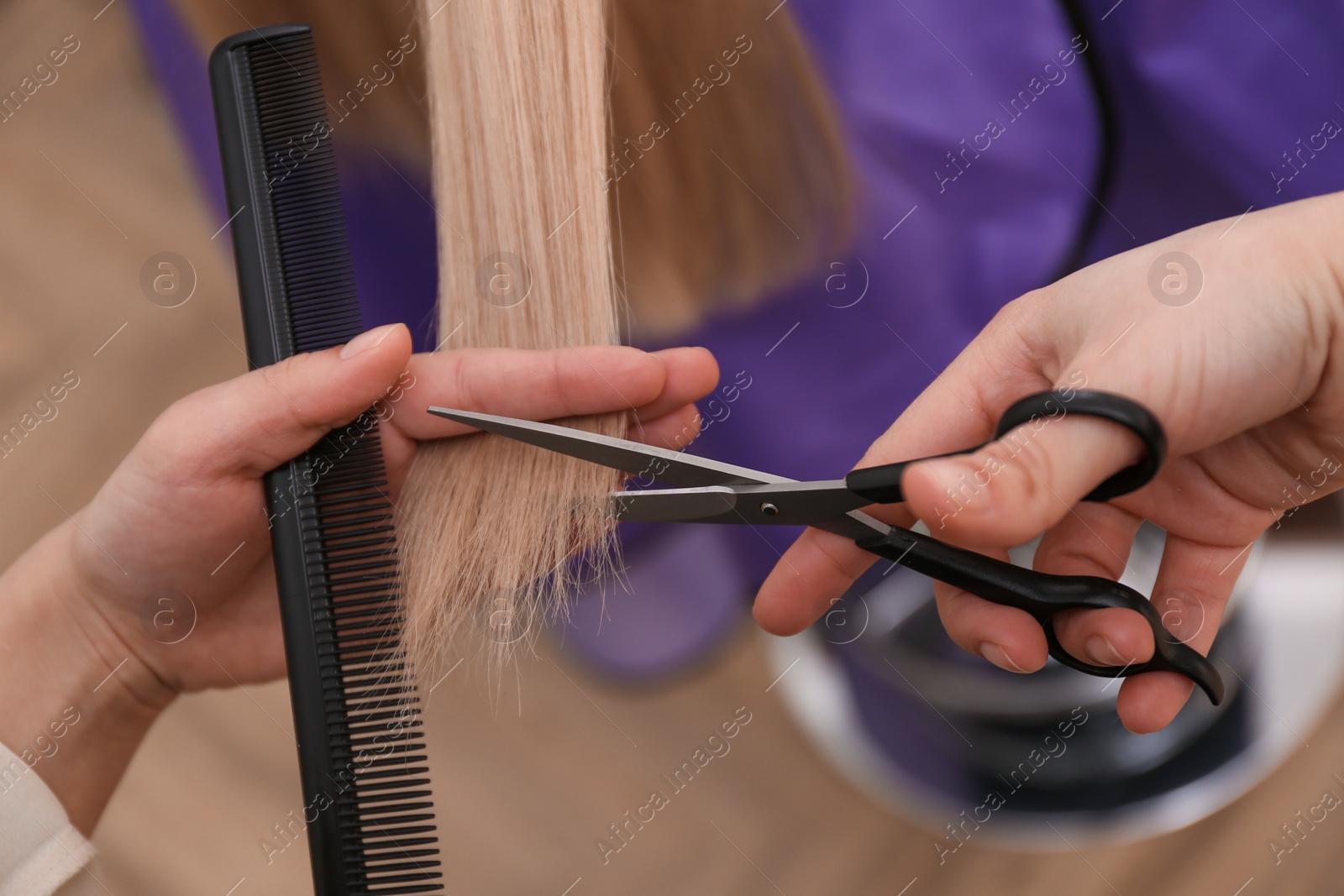 Photo of Stylist cutting hair of client in professional salon, closeup