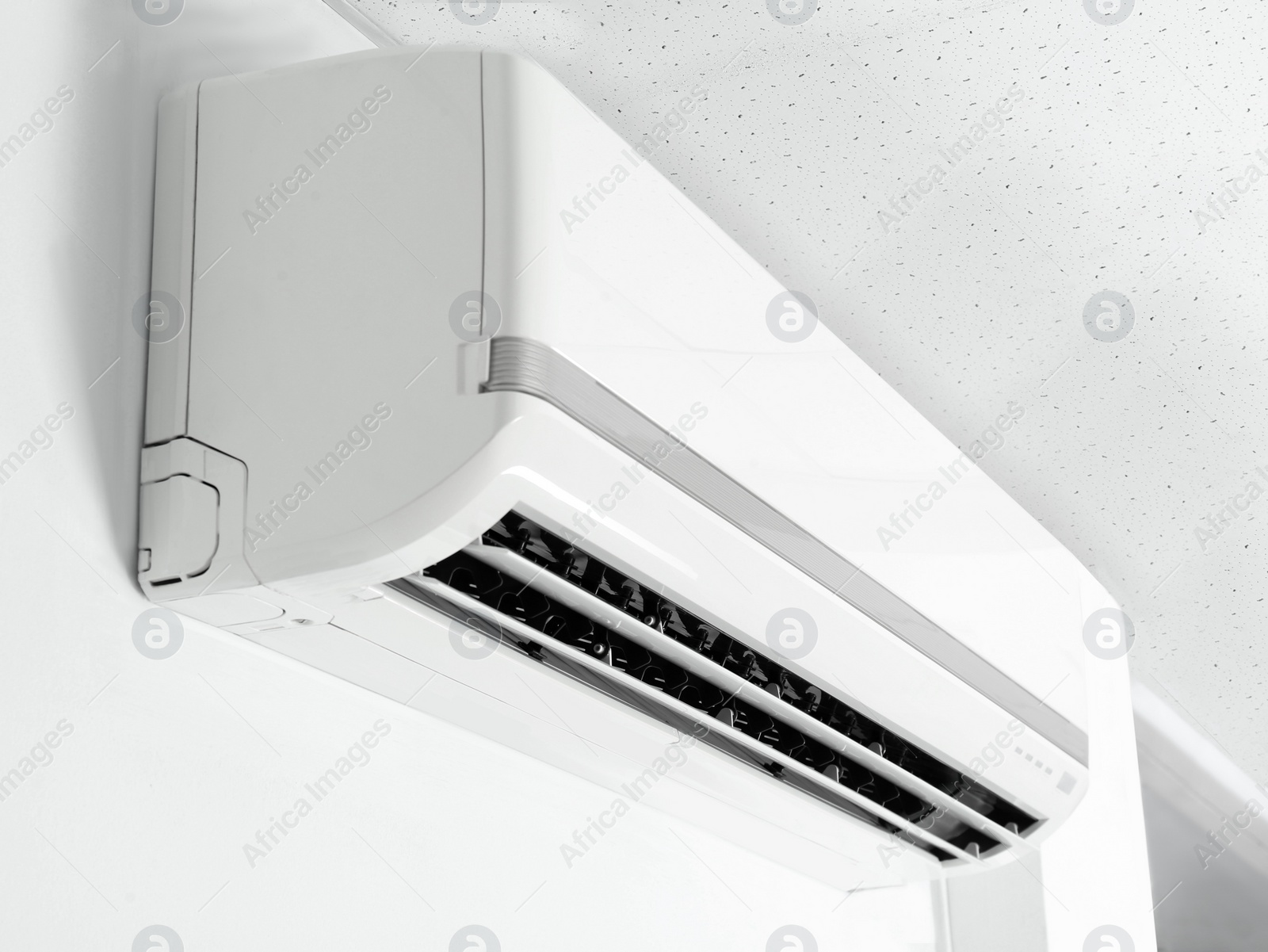 Photo of Modern air conditioner on white wall indoors