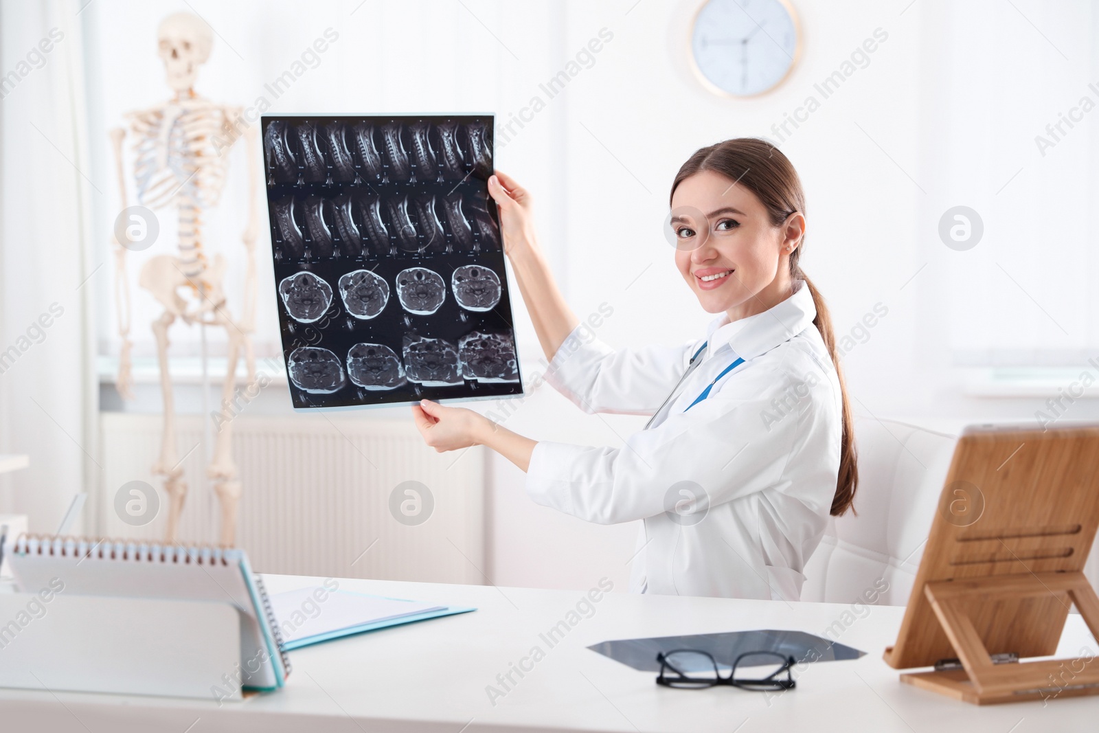 Photo of Orthopedist examining X-ray picture at desk in clinic