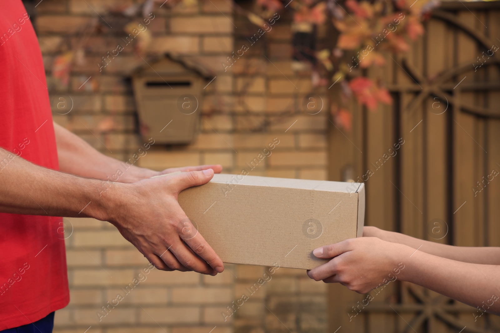 Photo of Man receiving parcel from courier outdoors, closeup